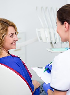 Dental team member taking notes during consultation