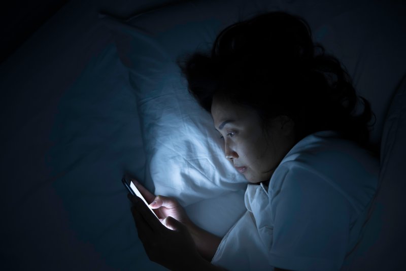 Woman using her phone in bed